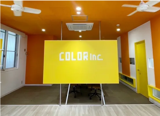 黄色い壁面が印象的な株式会社カラー 福岡ショールームの内観写真