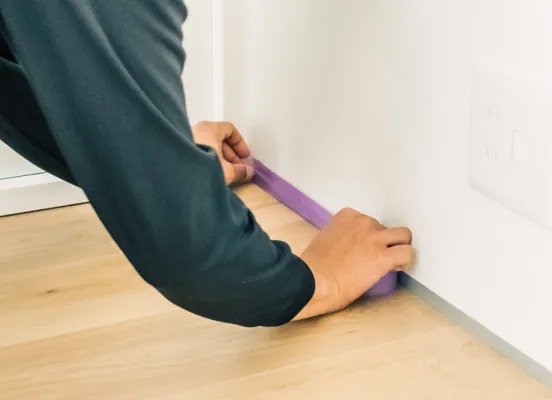 壁際の細部に養生テープを貼っている様子