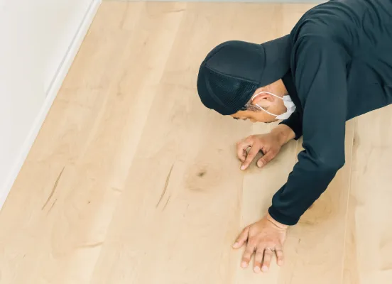 最終確認のため、床の表面を目視でチェックしているスタッフ