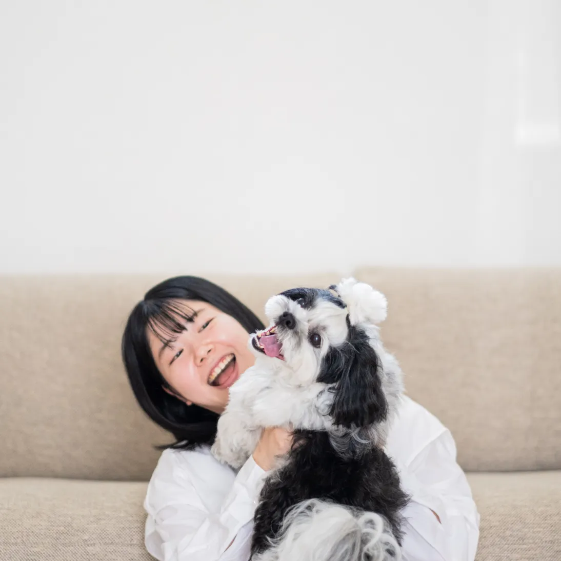 フロアコーティングされた床で愛犬と笑顔で過ごす女性